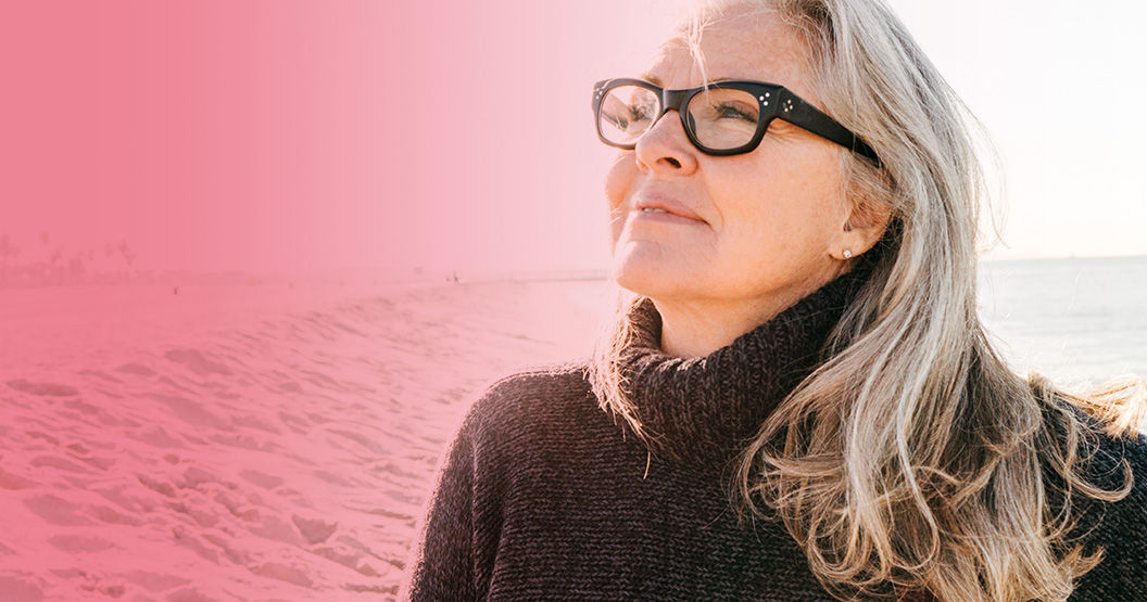 Middle-aged menopausal woman with glasses looking up and smiling