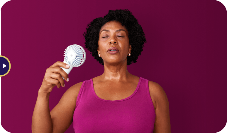 A woman using a fan to cool down