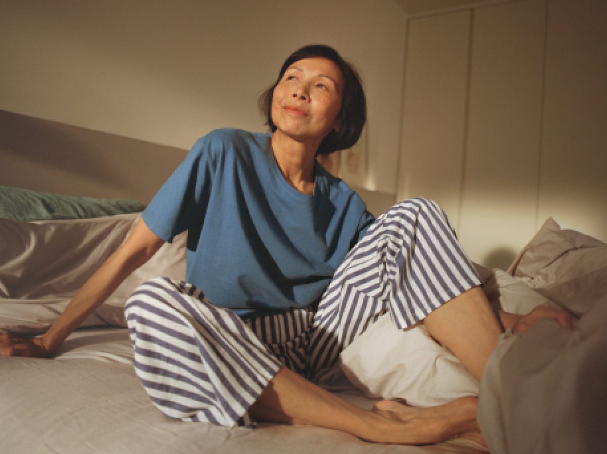 Middle-aged menopausal Asian woman looking at the camera confidently with light reflecting on her perspiration.