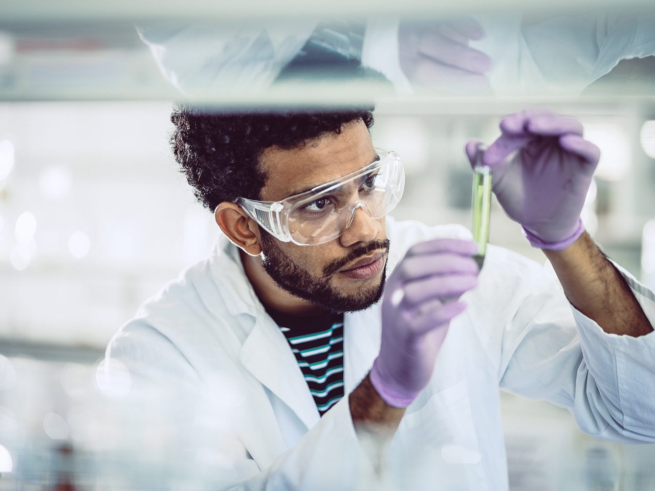 An Astellas scientist examines samples under a microscope, reflecting the company’s research-driven mission.