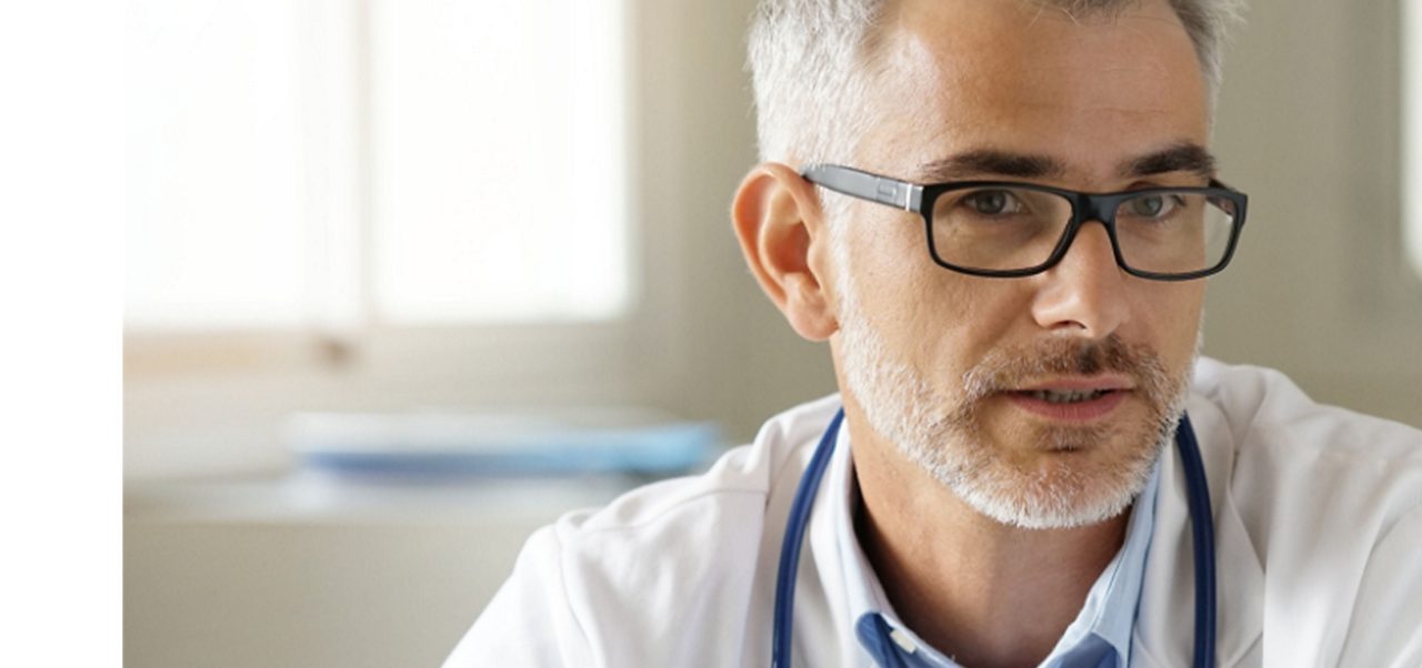 A doctor consulting a patient, illustrating Astellas’ commitment to improving access to medicines.