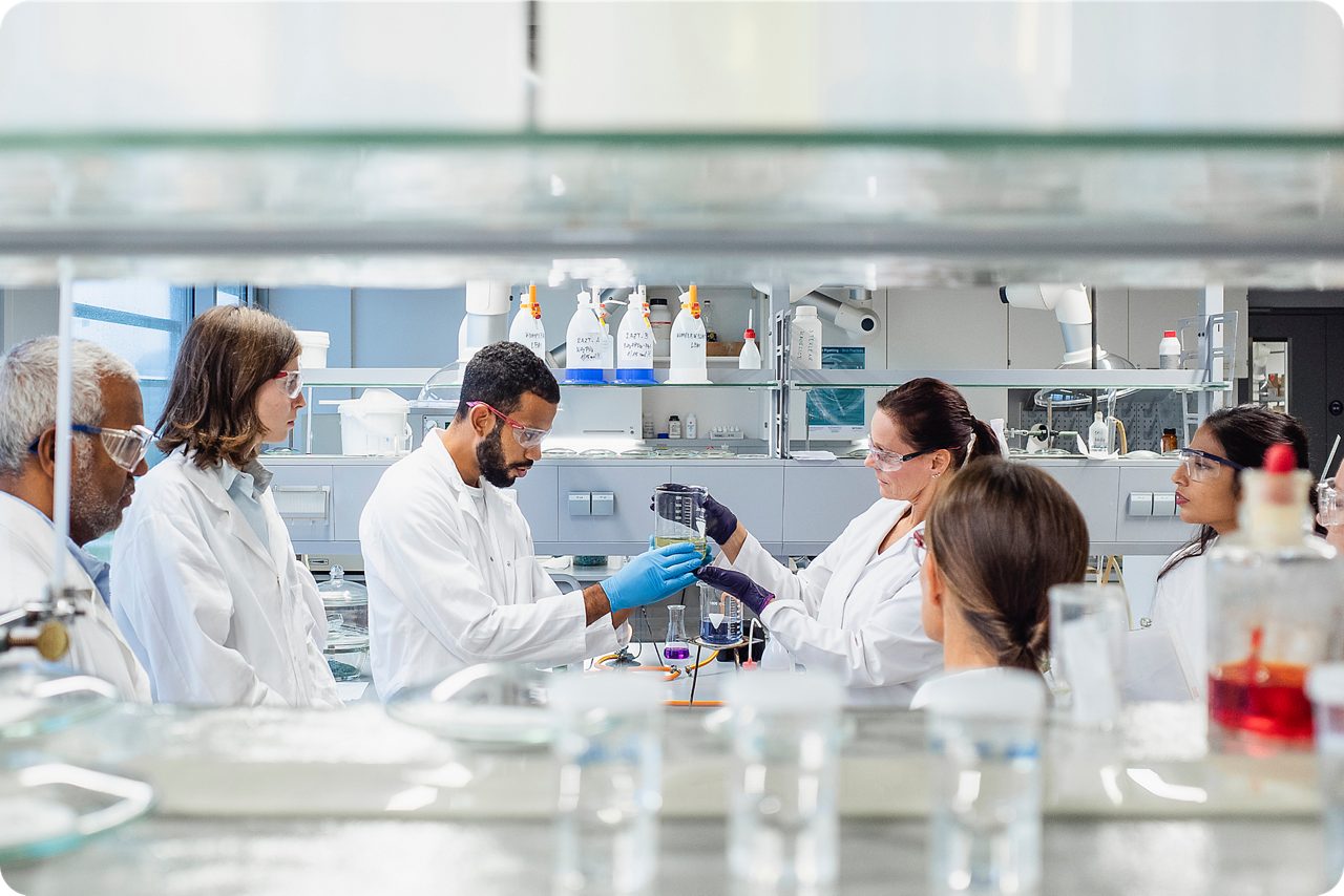 Astellas scientists work together at a whiteboard as part of  a culture that values bold ideas and collaborative  innovation.