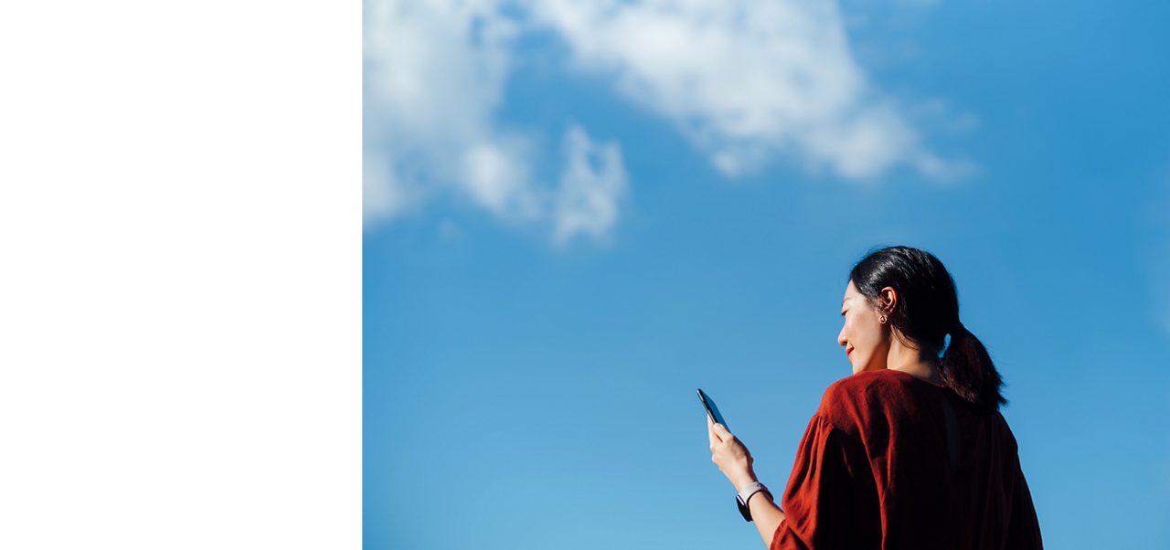 An Astellas employee holding a phone, reflecting on the company’s aim to be an Employer of Choice.