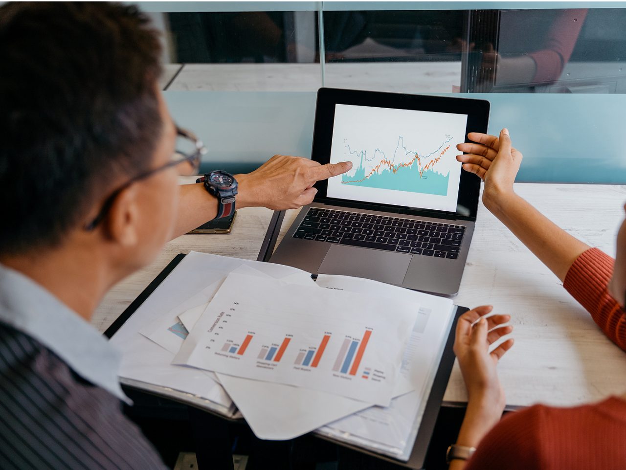 Astellas employees work on a laptop and examine the company’s strong financial results.