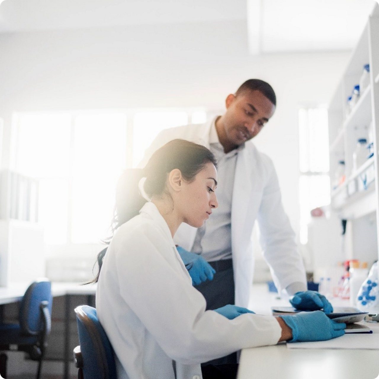 Two scientists review notes, showing how Astellas supports research activities that advance medical and scientific knowledge. 
