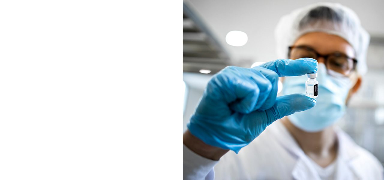 A researcher examines a vial in the lab, reflecting Astellas’ focus on drug R&D and delivering patient-first value through scientific innovation.