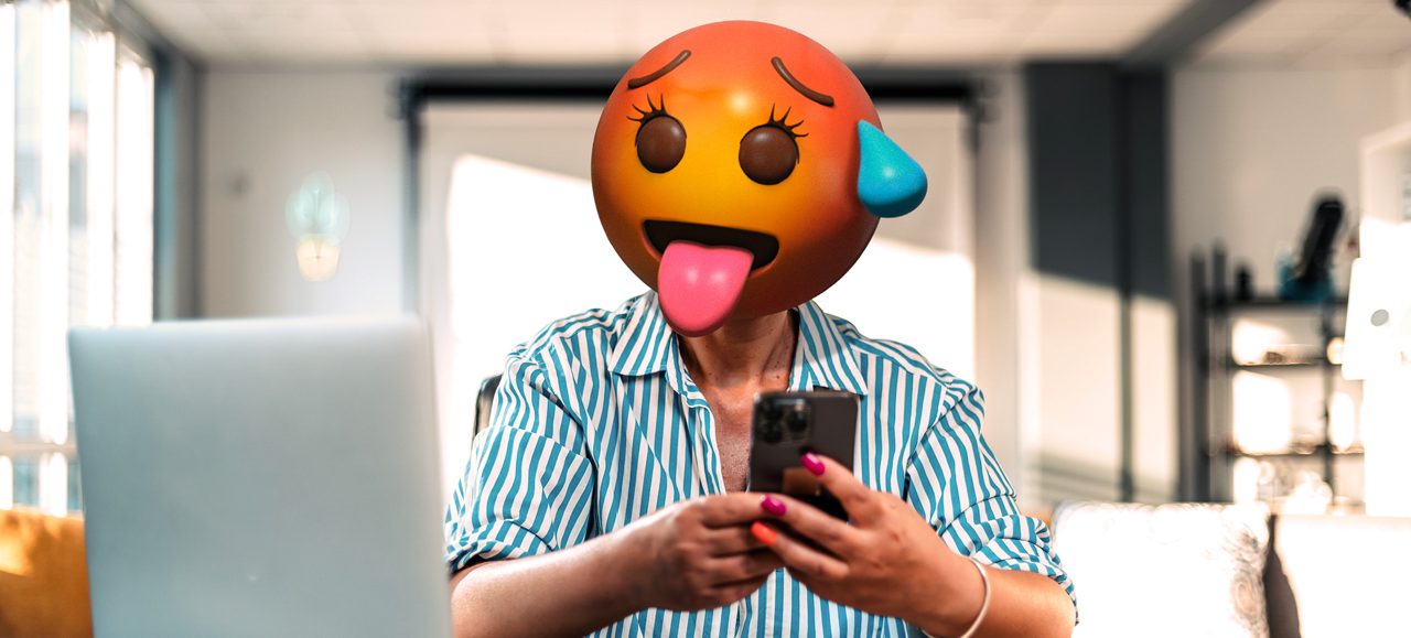 Kvinna med emojihuvud och telefon