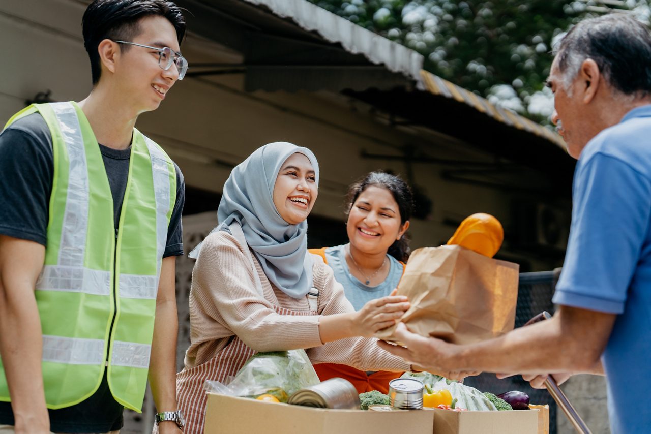 Astellas volunteers distributing food to those in need, supporting community health and fostering a stronger society.