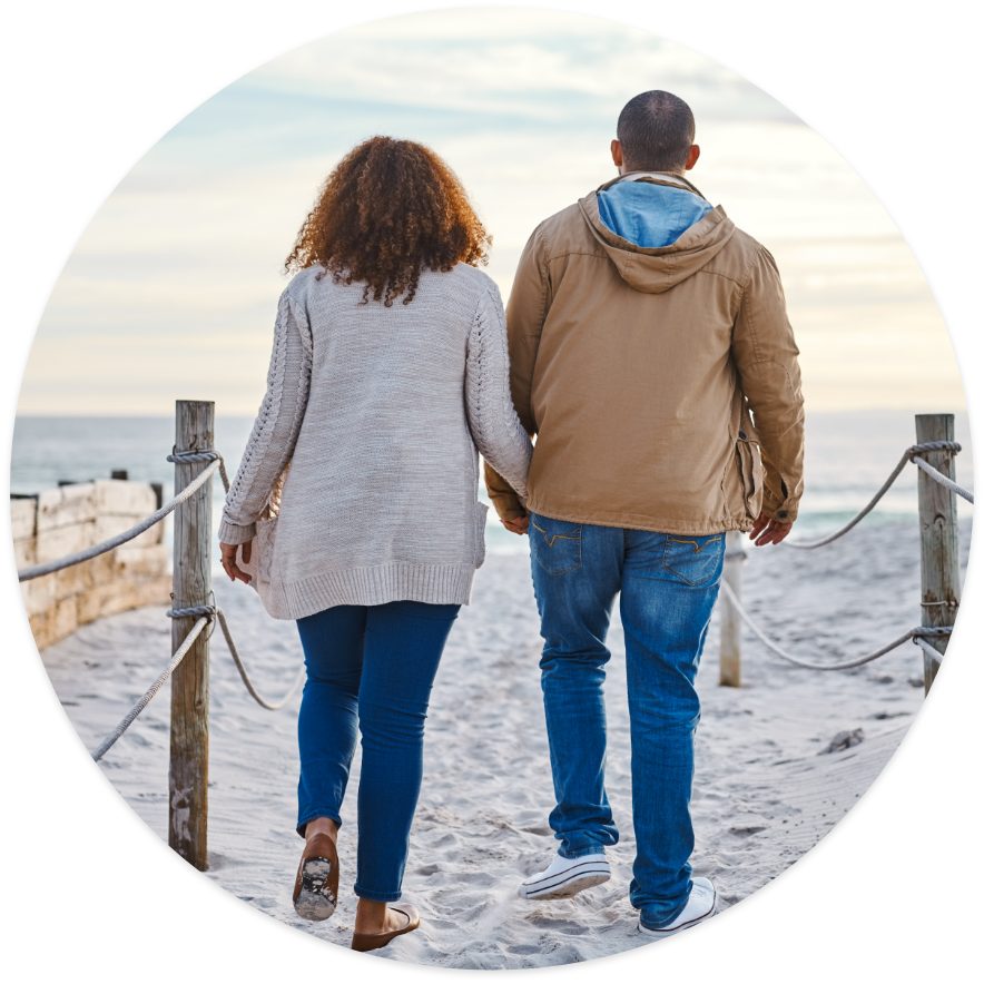 A woman and a man walks hand in hand near by the beach 