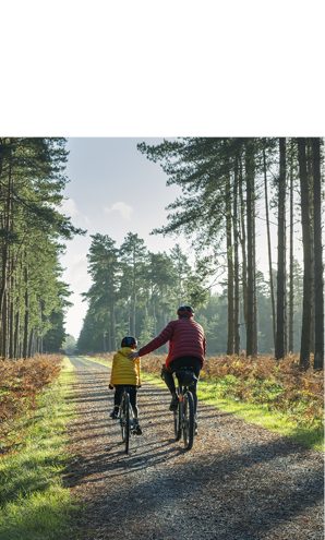 A father and child ride bikes, illustrating Astellas’ focus on sustainability issues.