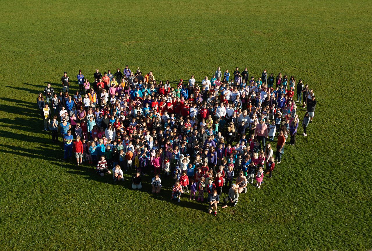 People forming heart-shape in park