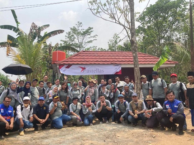 アステラスのインドネシアの社員が、地域コミュニティのイベントでボランティア活動をしながら、笑顔で写真に写っています。
