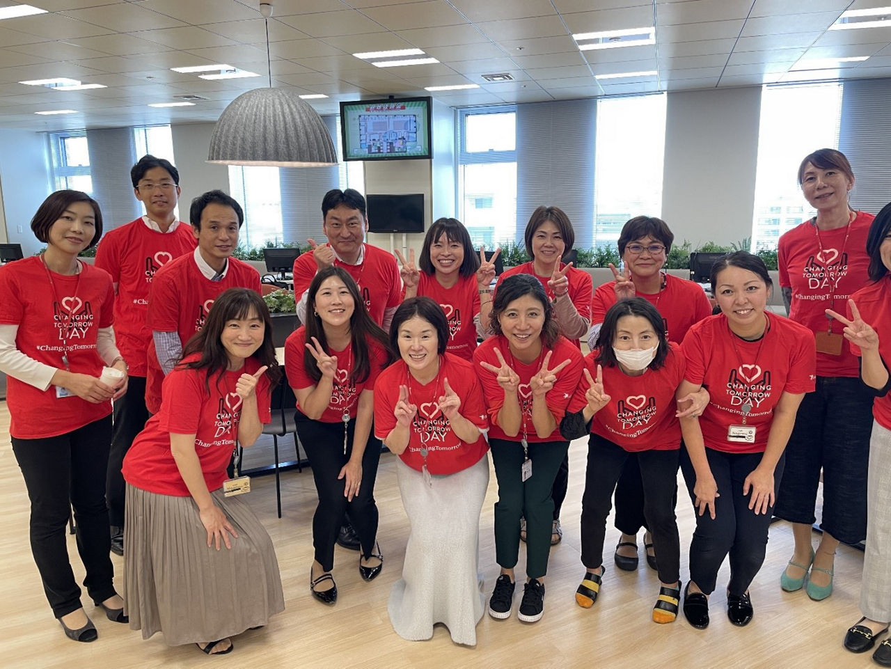 アステラスの日本の社員が、地域の病院でボランティア活動をしながら笑顔で写真に写っています。