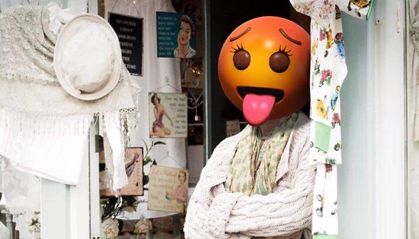 Kvinna i dörröppning med emojihuvud på