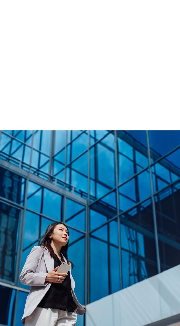 Young businesswoman walking against commercial building