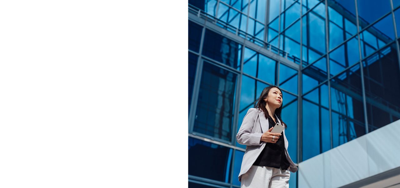 Young businesswoman walking against commercial building