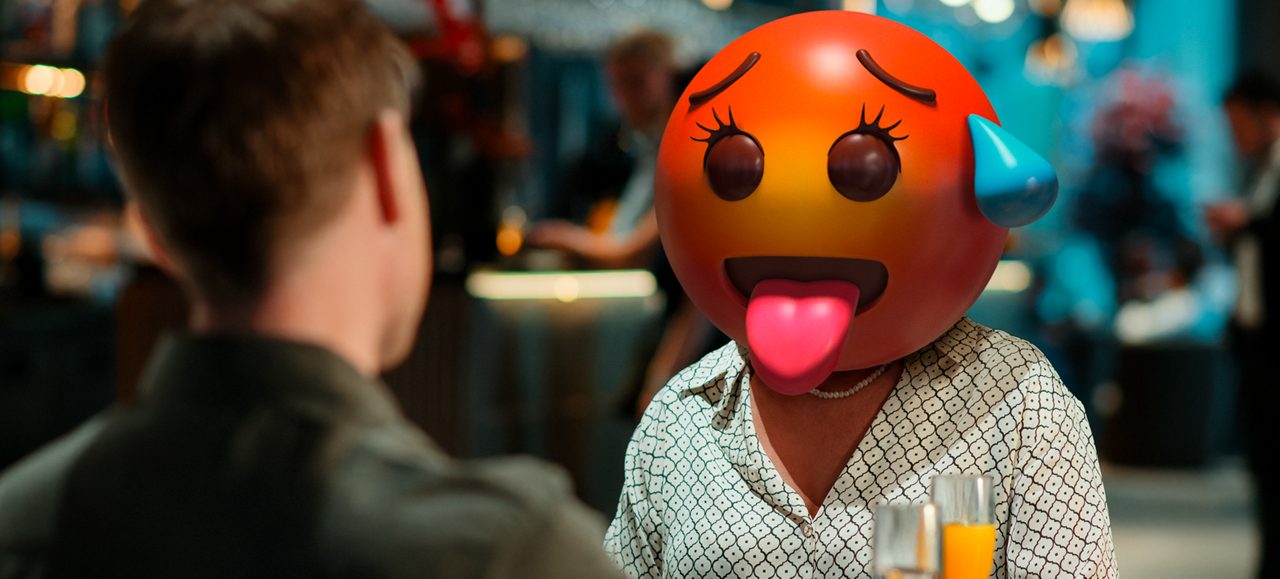 Kvinne på restaurant med emojihode