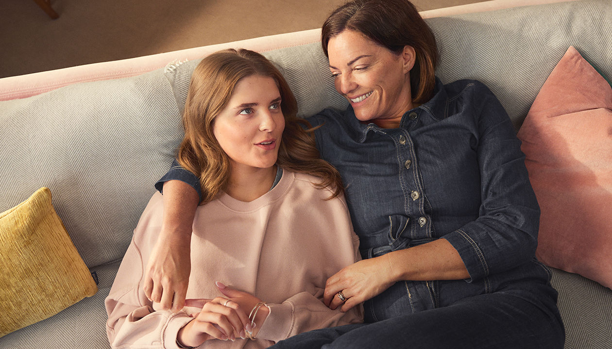 Tres mujeres con menopausia conversan y se ríen contando sus experiencias