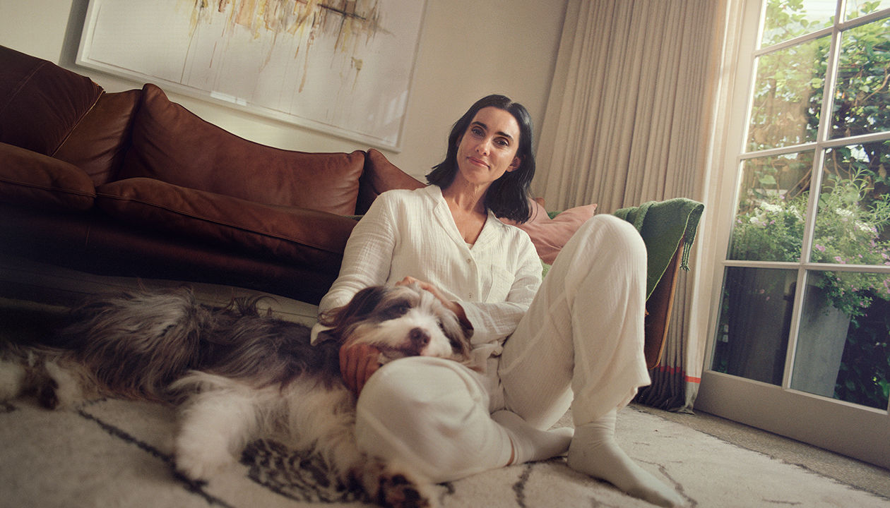 Una mujer con menopausia posa apoyada en la puerta su coche feliz tras contar su experiencia con los síntomas (SVM) 