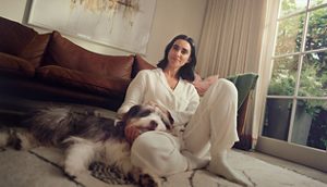 Una mujer con menopausia posa apoyada en la puerta su coche feliz tras contar su experiencia con los síntomas (SVM)