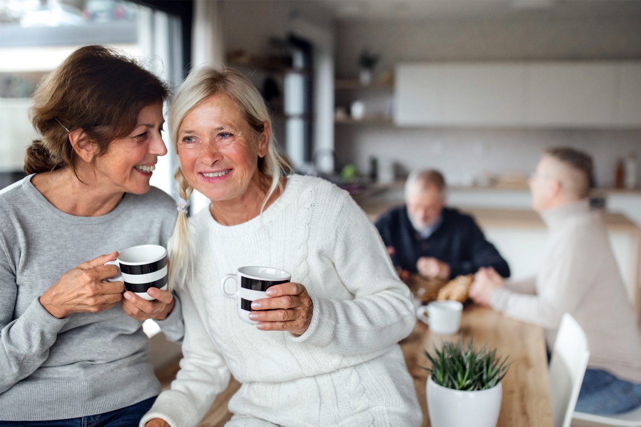 Vooraanzicht portret van senior vriendinnen met koffie thuis, praten.