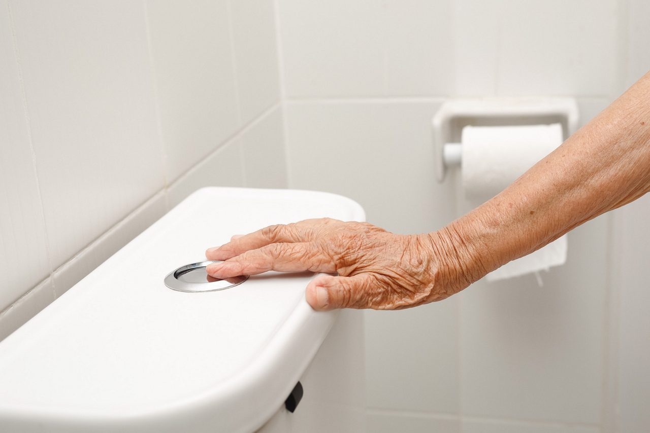 Bejaarde vrouw handspoeltoilet