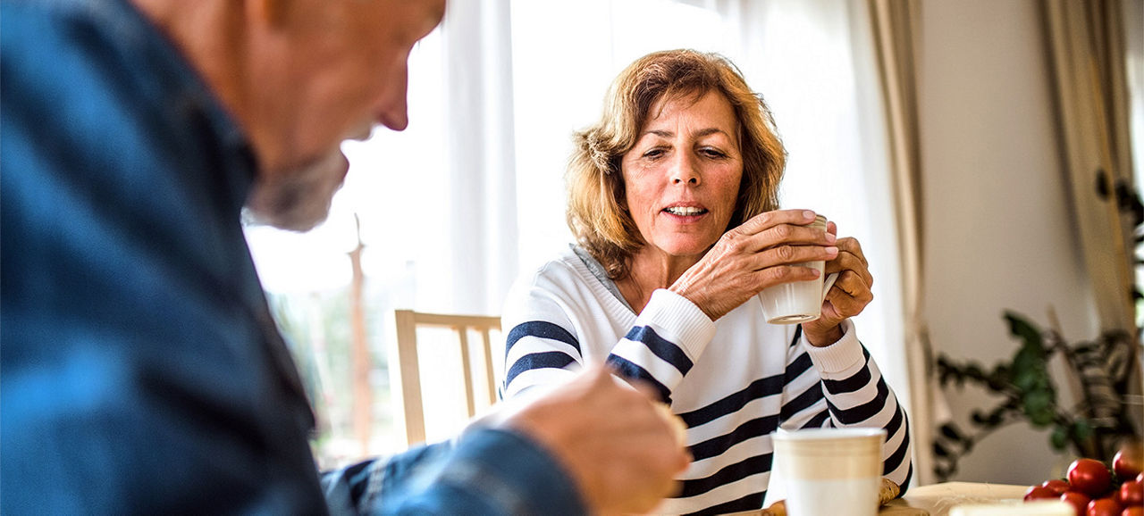 Senior couple eating breakfast at home. An old man and woman sitting at the table, eating breakfast.