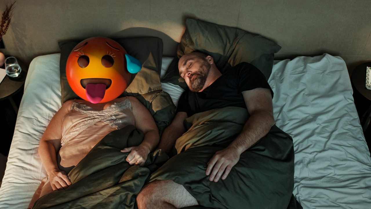 Par i sengen, kvinne med emojihode