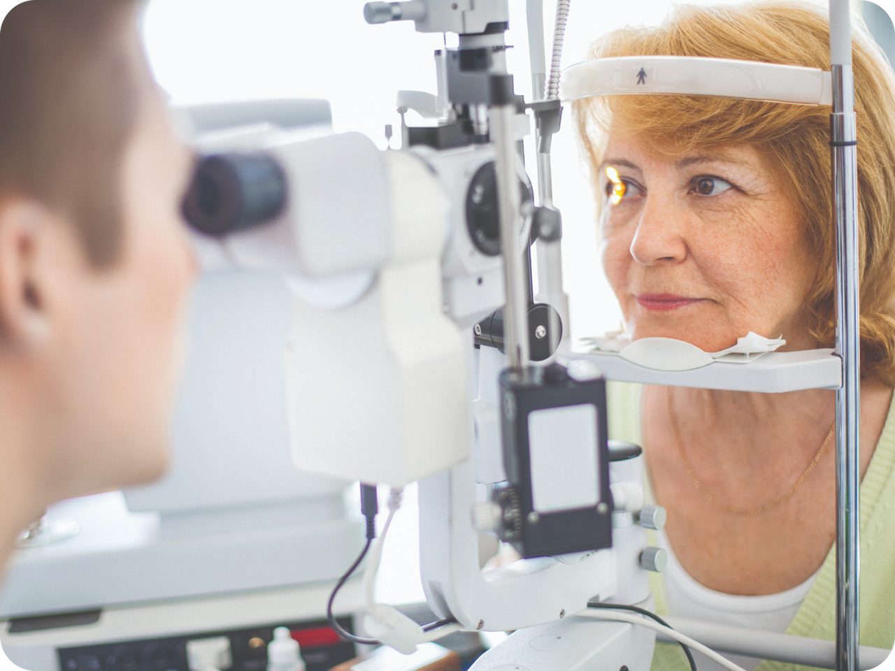 A woman undergoing an eye exam at a doctor's office, focusing on her vision and eye health.