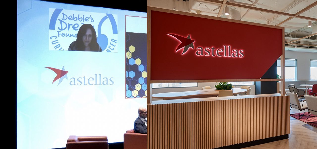 The Astellas logo displayed in a corporate office lobby, reflecting 20 years of innovation in pharmaceutical R&D and patient-centered therapies.