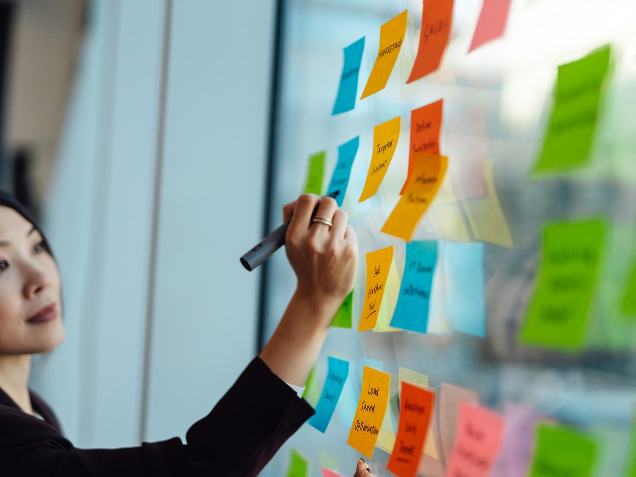 An Astellas employee posts notes on a wall, illustrating the company’s focus on driving innovation.