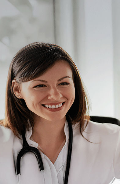 Eine lächelnde Ärztin mit einem Stethoskop spricht mit einem männlichen Patienten in einem hellen Büro.