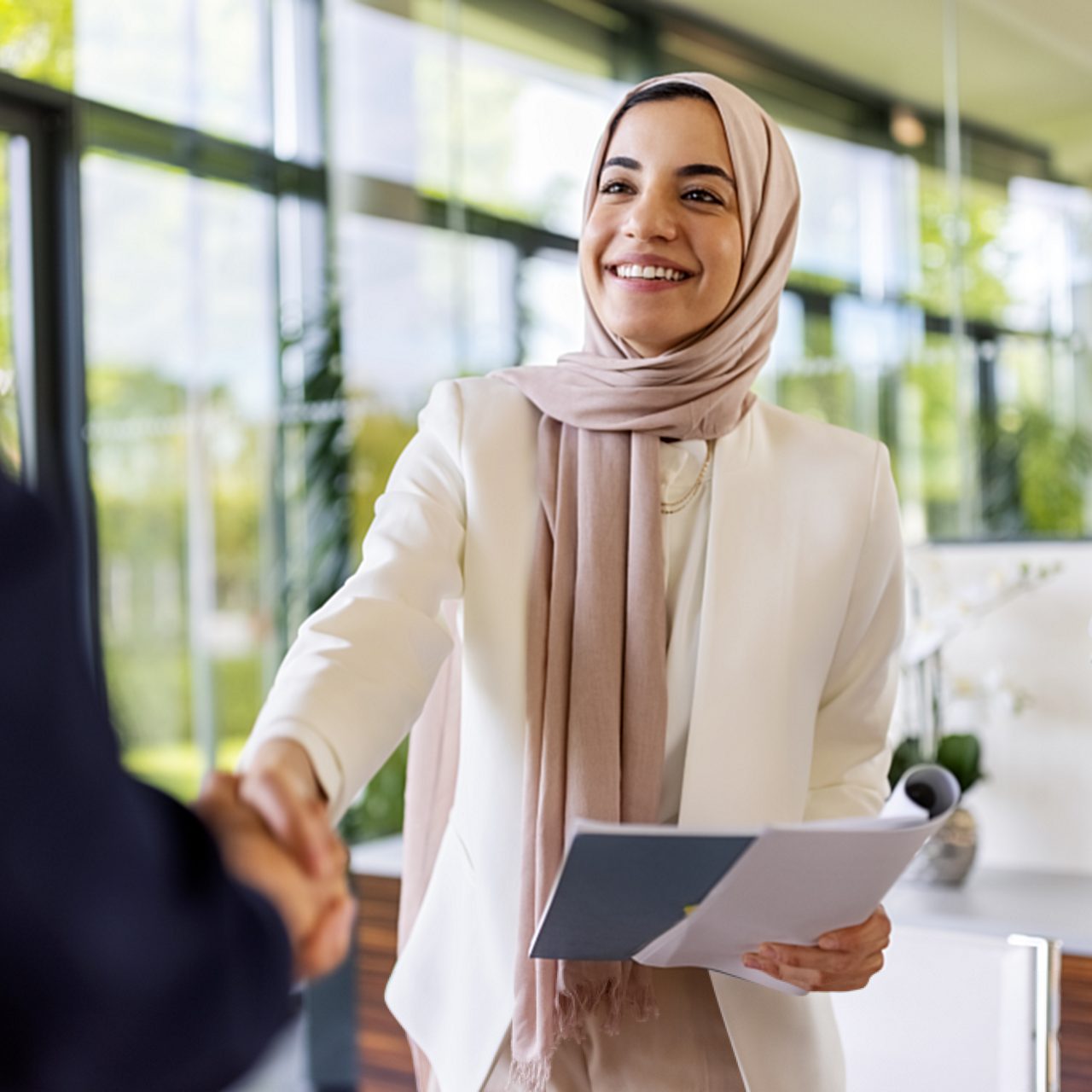 Astellas employee shakes hands with a partner, symbolizing collaboration with professional organizations and patient groups to advance care for transplant patients worldwide.