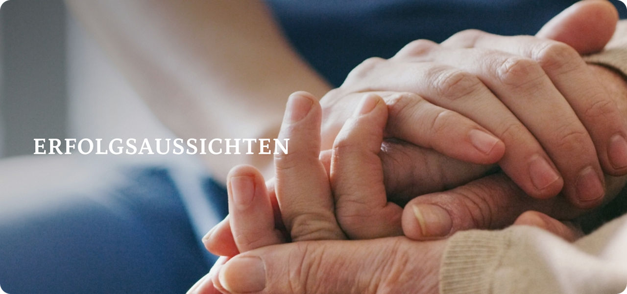 Nahaufnahme einer Pflegekraft, die die Hände eines älteren Menschen in einer tröstenden Geste sanft hält.