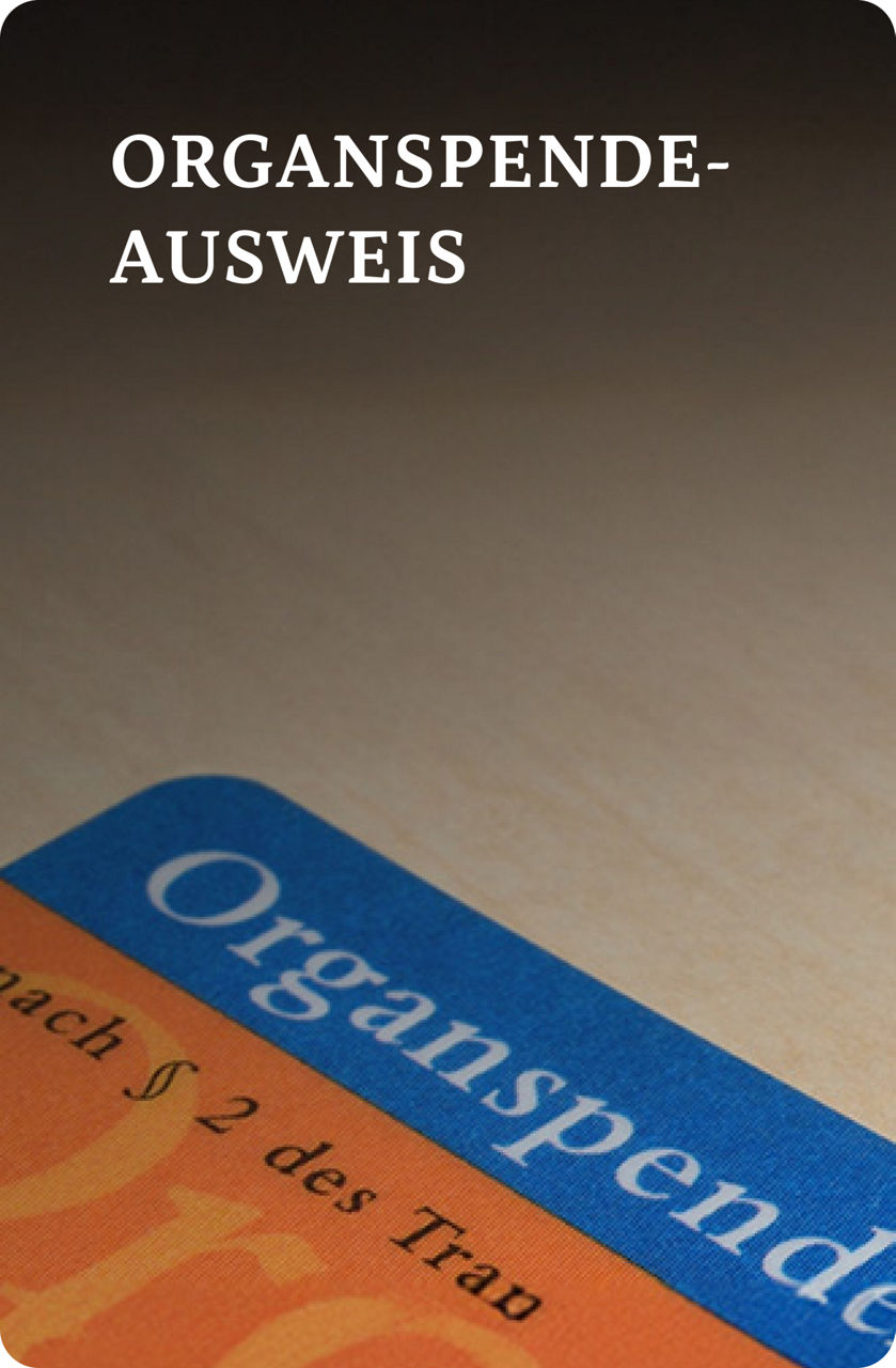 Eine Nahaufnahme eines deutschen Organspendeausweises auf einer hellen Holzoberfläche.