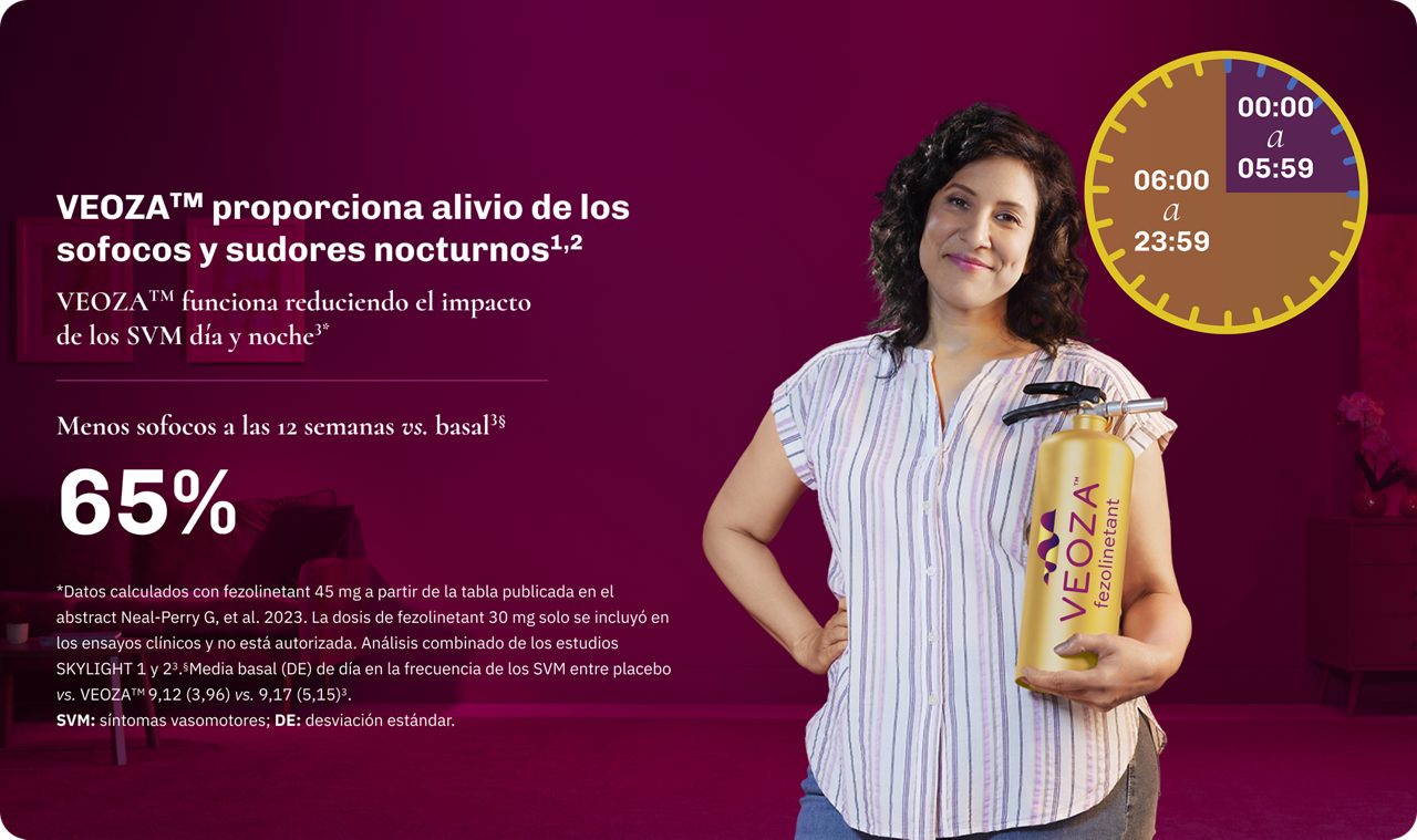Mujer sonriente sosteniendo VEOZA™ (fezolinetant) logo extintor de incendios en un dormitorio oscuro en cálida luz ámbar.