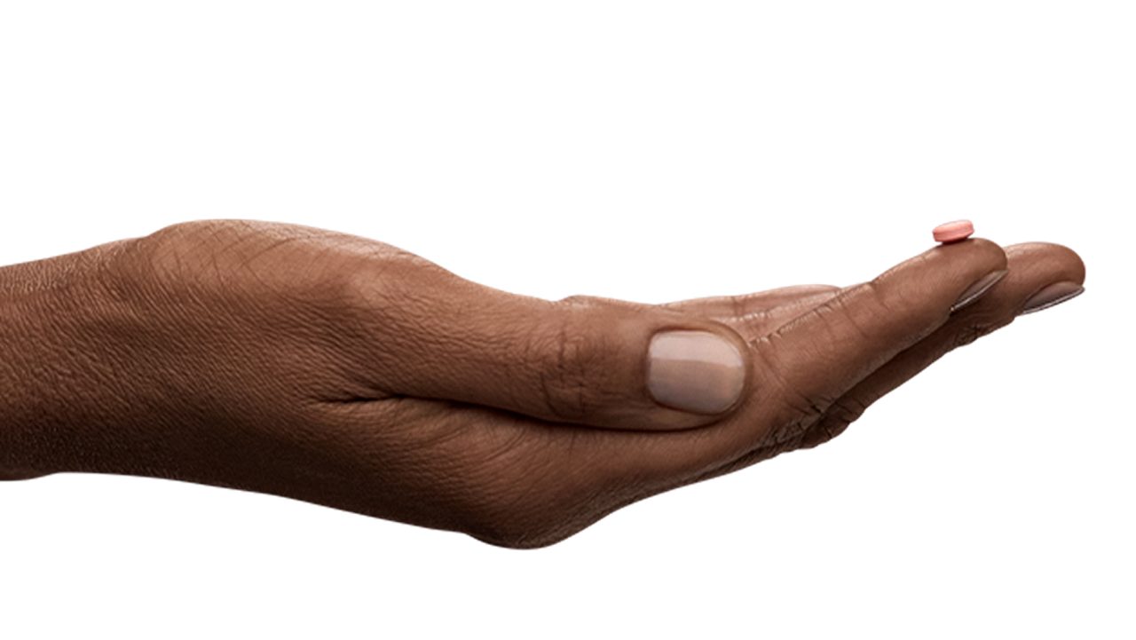 Hand holding a pill tablet