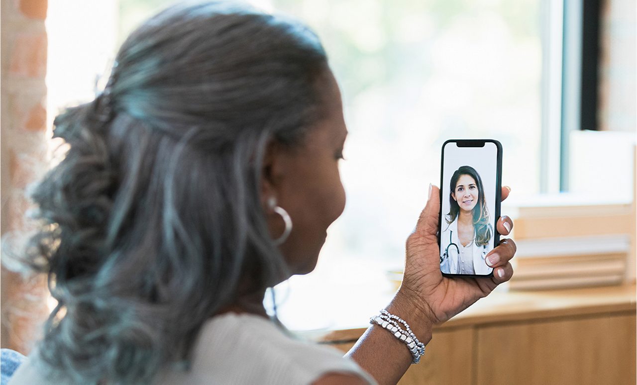 A woman talking with a healthcare provider on a smartphone