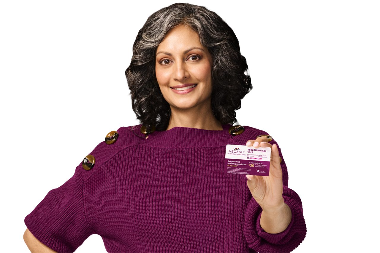 A lady holding a VEOZAH™ savings card