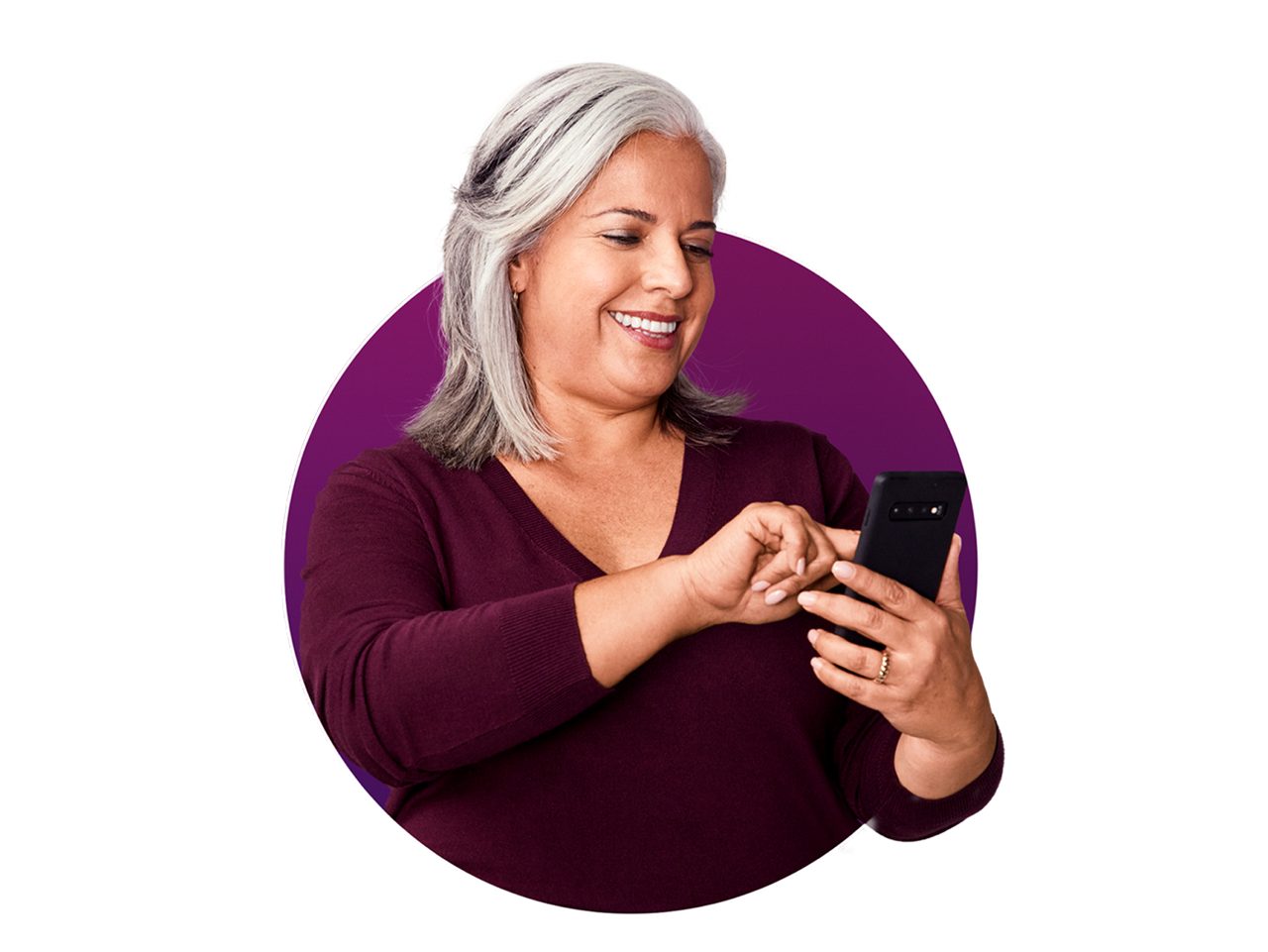 A lady holding a phone and smiling