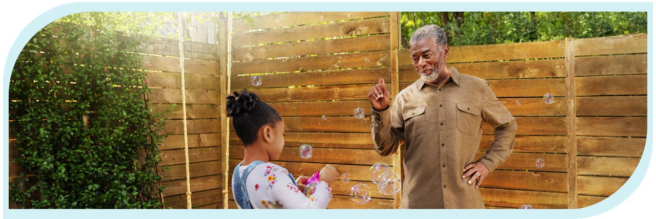 Grandfather and granddaughter blowing bubbles