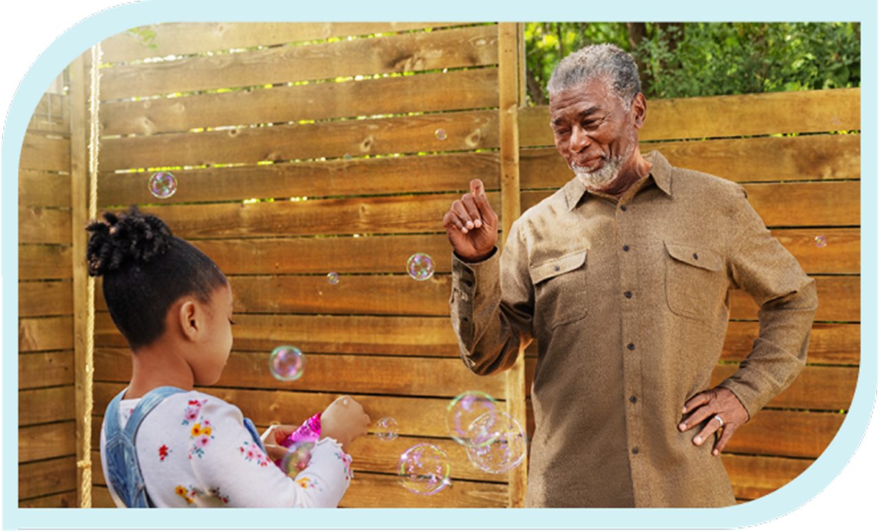 Grandfather and granddaughter blowing bubbles