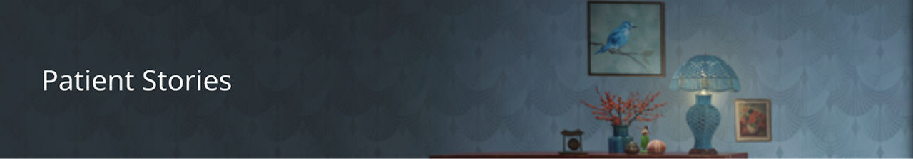 Shelf with lamp and flowers against a wall with two paintings.